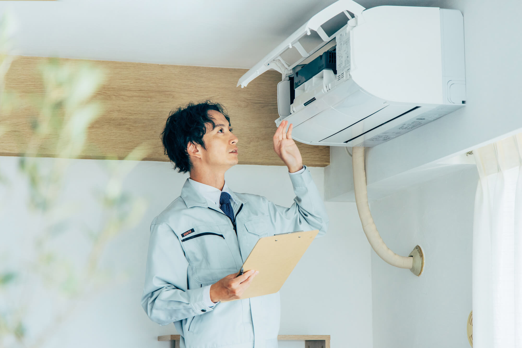 エアコンの故障原因を確認する男性