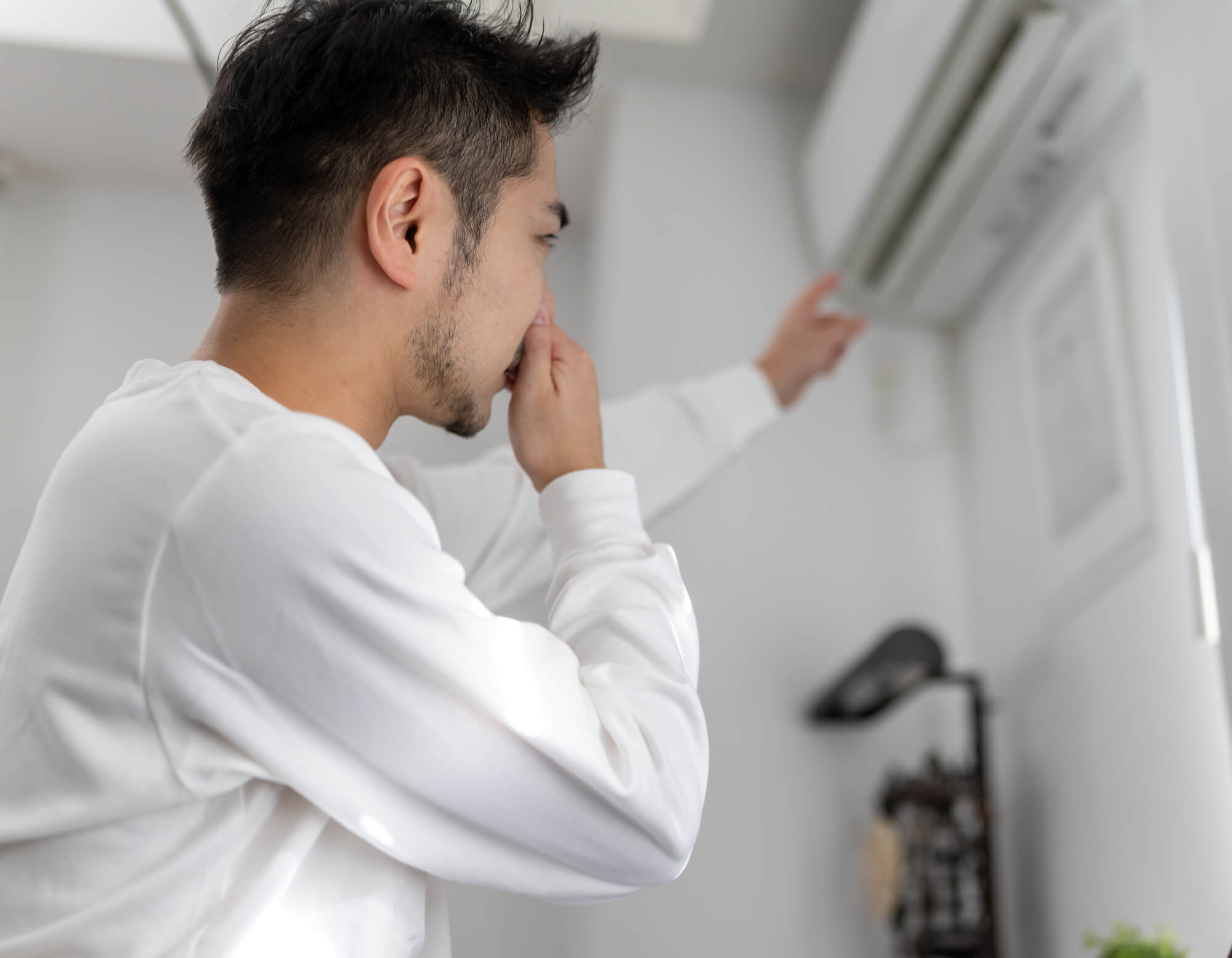 エアコンに悩む男性