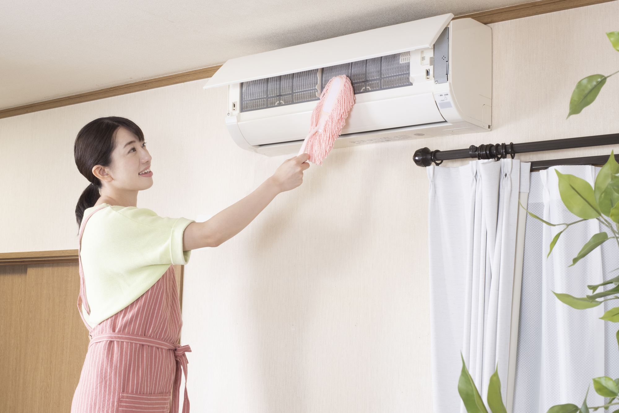 エアコンを掃除する女性