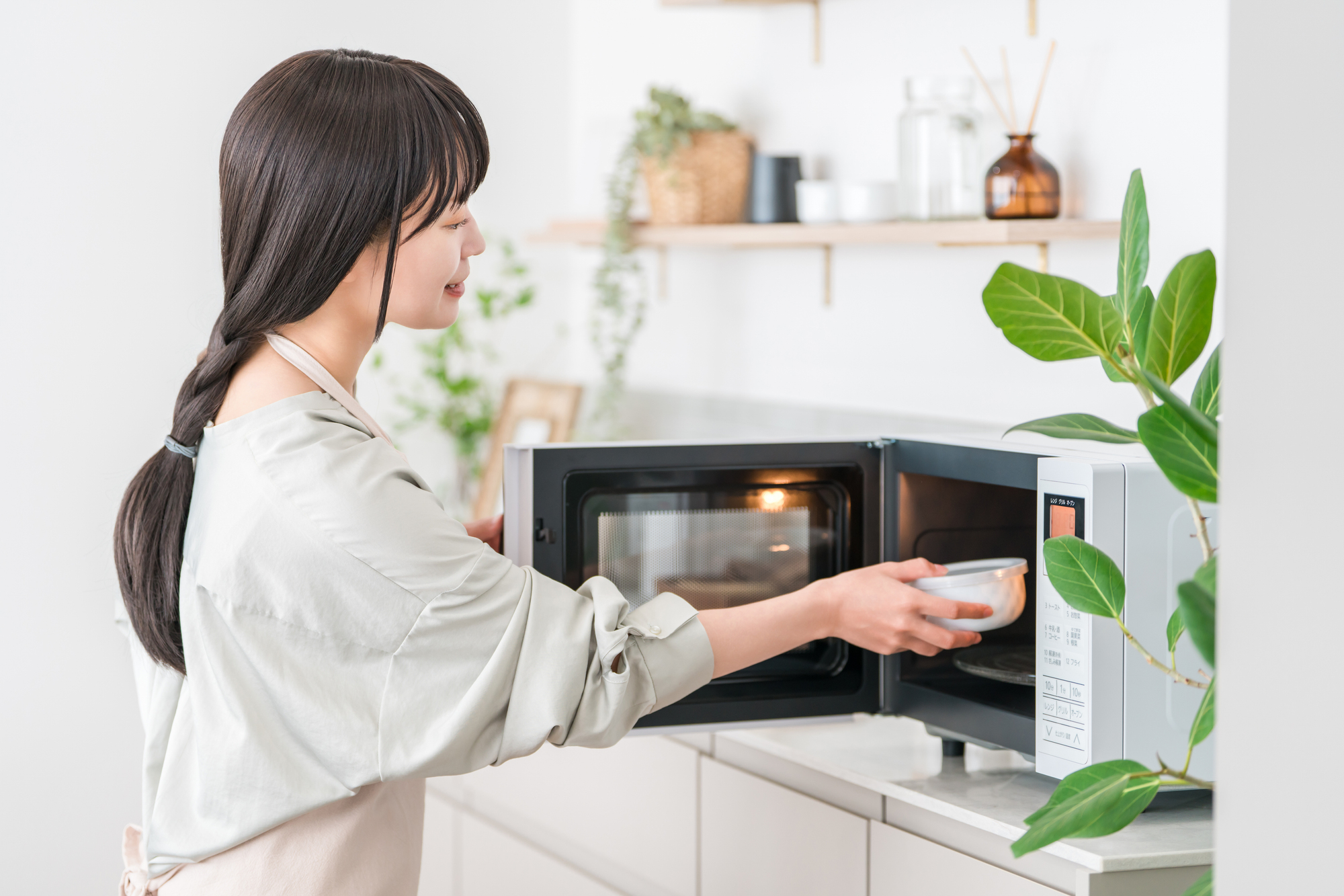 電子レンジを操作する女性